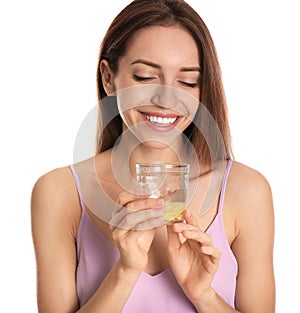 Young woman with glass of lemon water on background