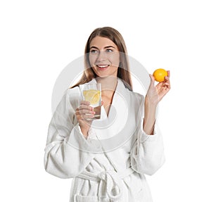 Young woman with glass of lemon water on background