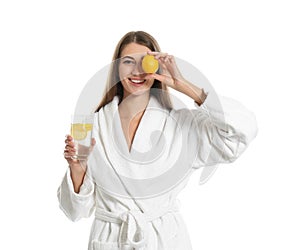 Young woman with glass of lemon water on background