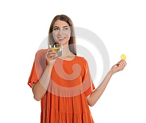 Young woman with glass of lemon water on white