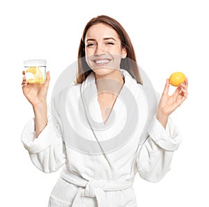 Young woman with glass of lemon water on white background