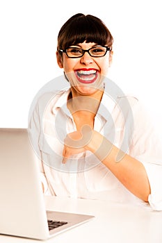 Young woman with glasses, laughing with a laptop.