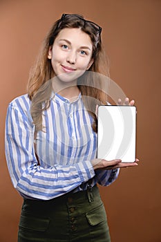 young woman in glasses showing tablet computer screen with smile, business woman concept, studio portrait