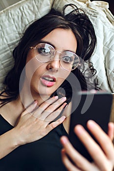 young woman with glasses using mobile phone