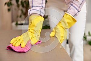 young woman cleaning table with microfiber cloth.