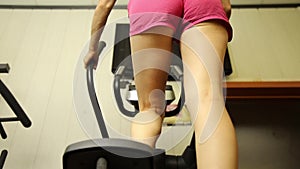 Young woman goes in for sports, fitness at the gym. girl doing exercises on the simulator