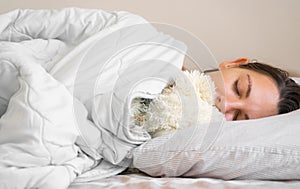 Young woman goes to sleep with teddy bear in her bedroom. Circadian rhythm. Biological clock. Sleep optimisation