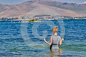 Young Woman going swimming in Lake Sevan of Armenia photo