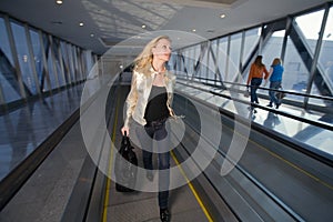 Young woman going on the travelator in a hurry