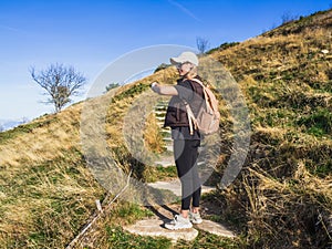 Young woman going up the stairs to the top of the mountain. The woman looking at her watch. Woman with a watch.