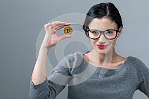 Young woman with a gold bitcoin coin