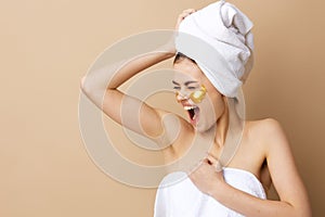 young woman golden patches on the face with a towel on the head close-up Lifestyle