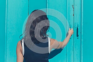 Young woman grabbing blue door