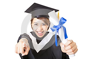 Young woman graduating and pointing to camera