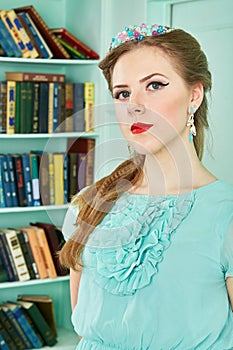 Young woman in green dress at library, half-length