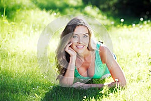 Young woman in green dress lying on grass
