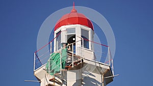 young woman in a green dress posing at the lighthouse against the backdrop of a beautiful landscape