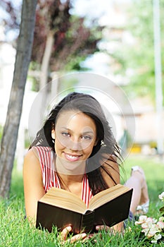 Young woman in green park, book and reading