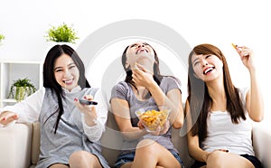 young woman group eating snacks and watching the tv