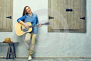 Young woman guitar playing on street.