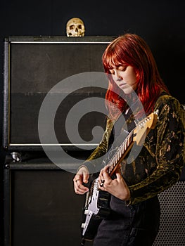 Young woman guitarist in a recording studio