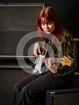 Young woman guitarist in a recording studio