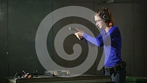 Young woman with the gun on an indoor shooting range. collect gun