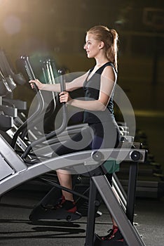 Young woman at the gym exercising. Run on machine.
