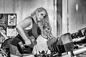 Young woman in the gym lifting weights
