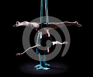 Young woman gymnast with blue gymnastic aerial silks