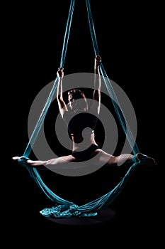 Young woman gymnast with blue gymnastic aerial silks