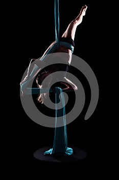 Young woman gymnast with blue gymnastic aerial silks