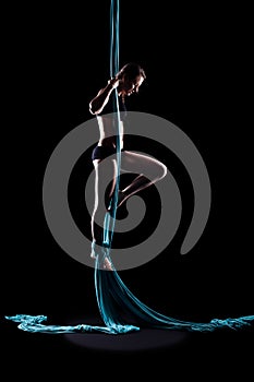 Young woman gymnast with blue gymnastic aerial silks