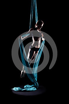 Young woman gymnast with blue gymnastic aerial silks photo