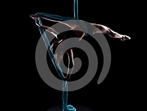 Young woman gymnast with blue gymnastic aerial silks photo