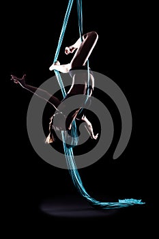 Young woman gymnast with blue gymnastic aerial silks photo