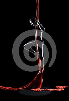 Young woman gymnast with red gymnastic aerial silks