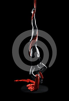 Young woman gymnast with red gymnastic aerial silks