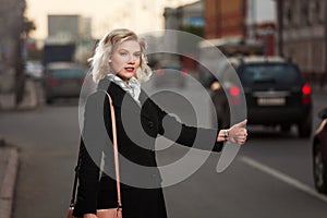 Young woman hailing a taxi cab photo