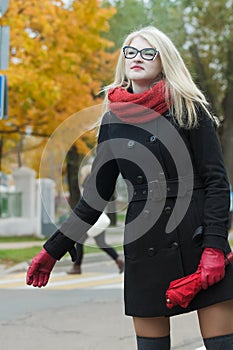 Young woman hailing taxi cab with holding out her