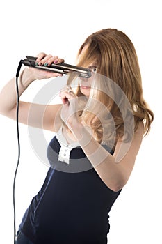 Young woman with hair straightener