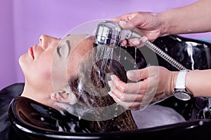 Young woman at hairdresser wash hair