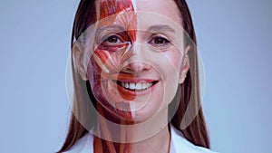 Young woman with half of face with muscles structure under skin. Model for medical training on a light background. Close