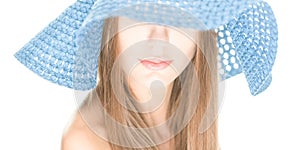 Young woman with half hidden face under blue hat.
