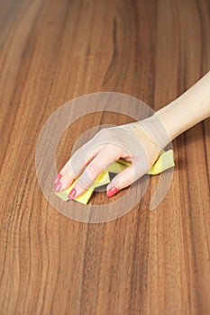 Young woman hand cleaning modern wood table by dust cloth, cleaning concept