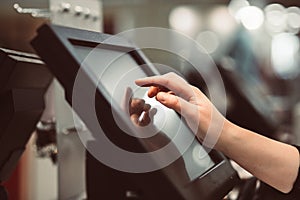 Young woman hand doing process payment on a touchscreen cash register, POS, finance concept