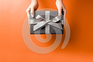 Young woman hand with a gift box offer to receiver