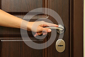 Young woman hand hold wooden door handle