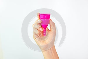 Young woman hand holding a pink menstrual cup