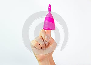 Young woman hand holding a pink menstrual cup